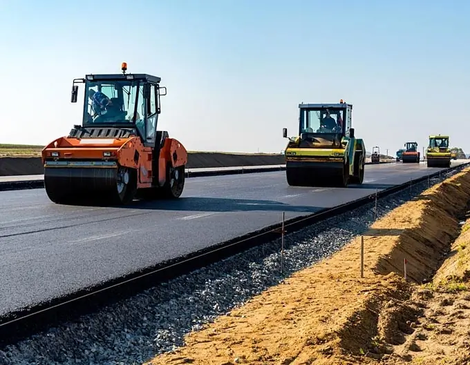 maquinas aplanando el asfalto en construccion de una carretera nueva cementos torices 